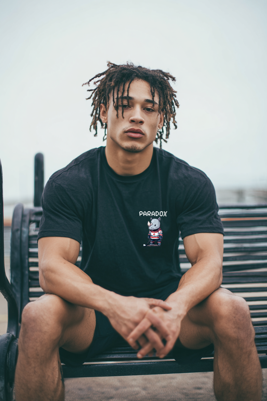 Black t-shirt with a graphic pixel art of a rhino playing ice hockey on a male model